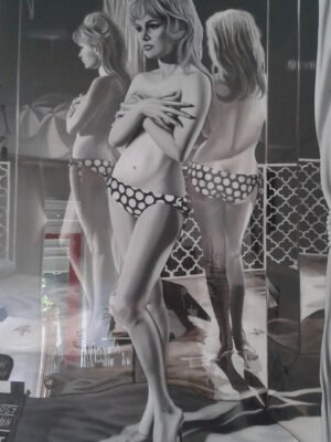 Black and white wall art of a vintage-inspired woman in a polka-dot bikini, reflected in mirrors, creating a striking effect.