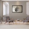 Luxury handbag painting framed between two elegant chairs in a contemporary sitting area.