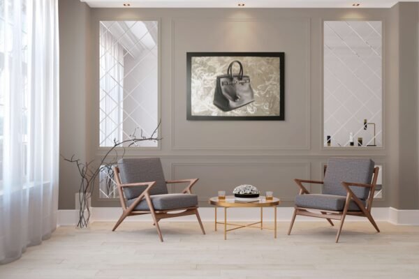 Luxury handbag painting framed between two elegant chairs in a contemporary sitting area.