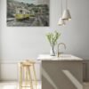 Public art urban light painting of Lisbon trams mounted above a minimalist kitchen island with pendant lights and wooden stools.