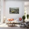 Public art urban light painting displayed above a modern white sofa in a bright living room with large windows, plants, and minimalist decor