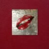 Red lips pop art painting on a textured silver background displayed on a deep red wall.