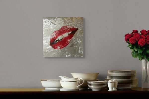 Red lips pop art painting on a textured silver background displayed above a dining setup with roses and ceramic dishes.